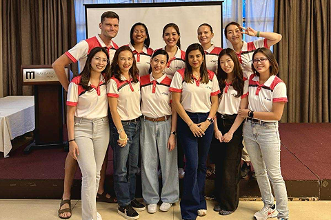 Team members in matching shirts, posing together during a company event.