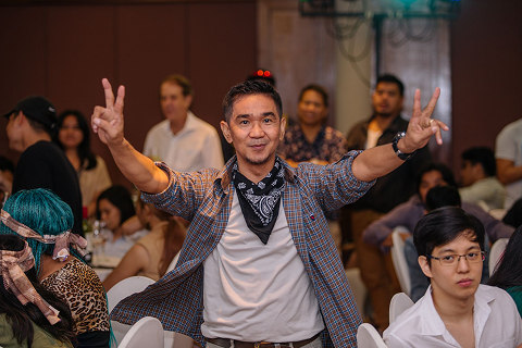 A colleague posing with peace signs at a company social event.